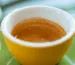 Espresso servito in una tazzina gialla su piattino verde presso CoffeeStorming.